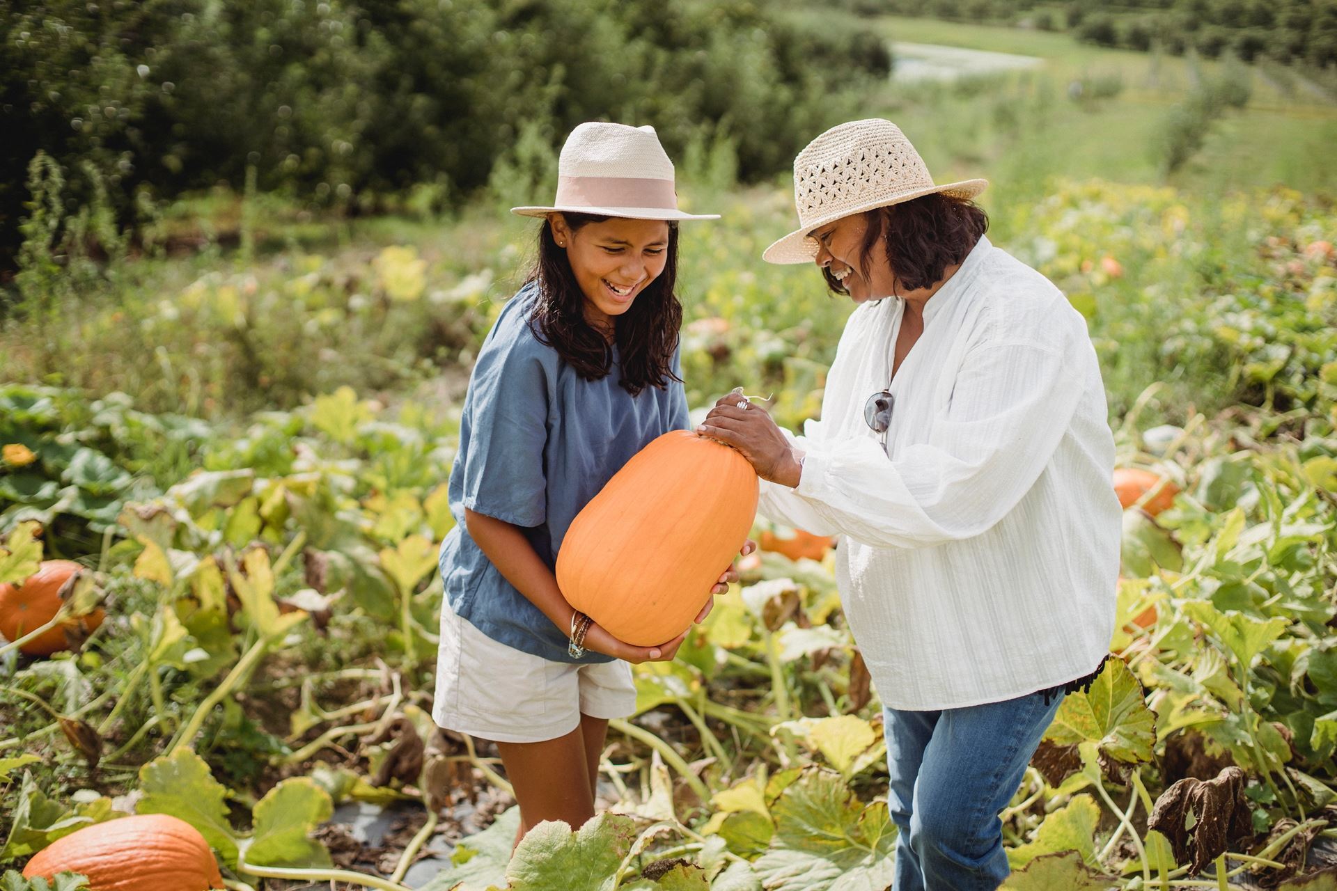 woman and child selecting pumpkin in patch