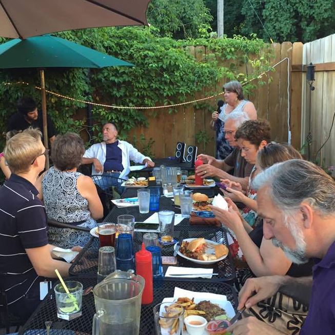 Members at an outdoor meetup enjoying dinner and good conversation